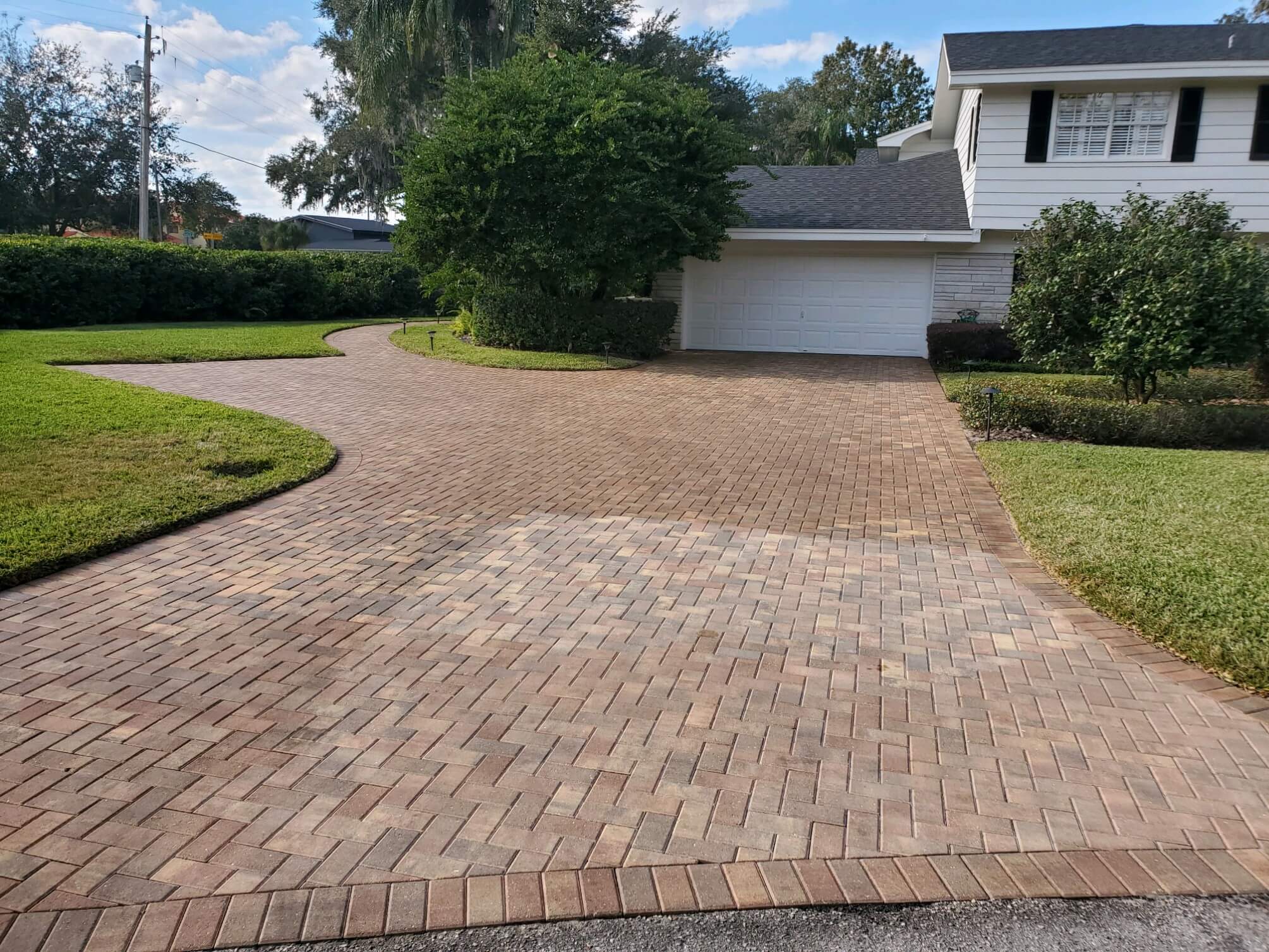 Paver driveway cleaned and sealed in Auburndale, FL by PCE Pressure Washing, showcasing a restored and vibrant finish.